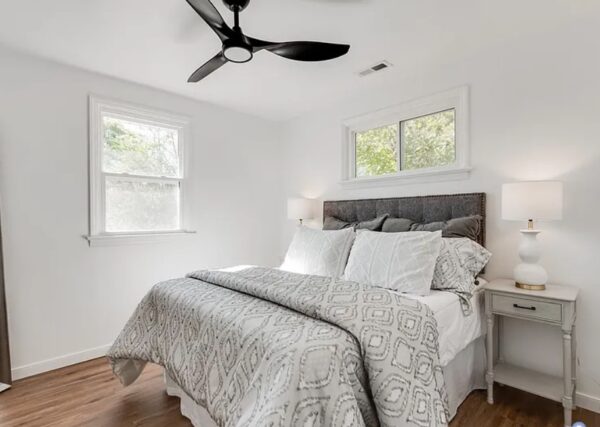 After shot of a bedroom with light grey furnishings taken from a successful Borrower rehab project funded by Marie William Capital.