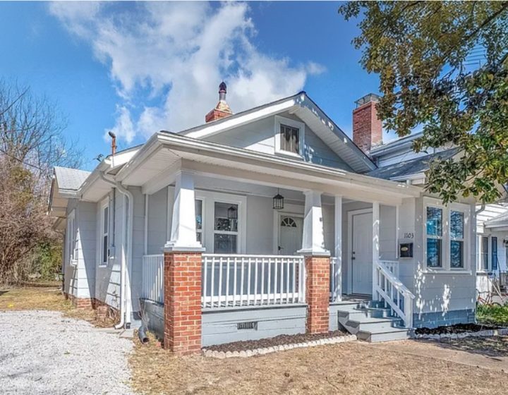 After shot of the front of a white single story house with a porch and columns with brick bases, a successful Borrower rehab project funded by Marie William Capital.